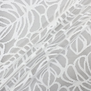 three diagonal lines arranged with a piece of white colored filet-crochet lace with a monstera leaf pattern