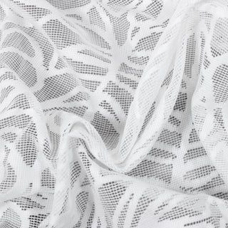 close-up of white piece of filet-crochet monstera pattern lace