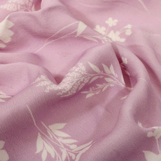 close-up of lavender and white colored floral patterned crepe back satin fabric, detailing its subtley-textured face and matte appearance