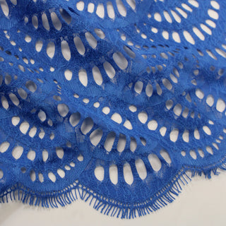 close-up of blue lace fabric detailing its motif and scalloped eyelash edge