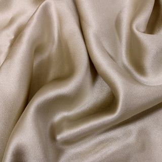 close-up of champagne colored silk charmeuse fabric, detailing the satin weave