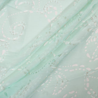 three diagonal lines arranged with seafoam green crinkle chiffon fabric that has cutout patterns throughout