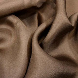 close-up of bronze colored silk mikado fabric, detailing its twill weave