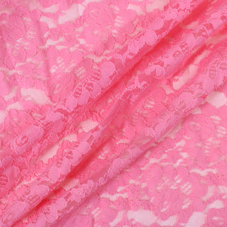 three diagonal lines draped of a pink stretch lace floral mesh fabric, demonstrating its sheer nature, drapeability, and lightweight hand