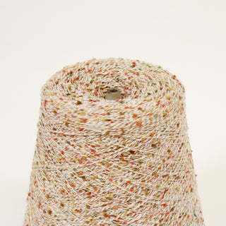 close-up of a cone of lace-weight multicolored flecked slub yarn in an autumnal color palette