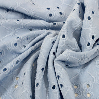 close-up of a baby blue eyelet jersey fabric, detailing its knit structure and eyelet cutouts