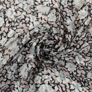 swirl of black, pink, and white floral printed silk crinkle chiffon fabric, demonstrating the drape 