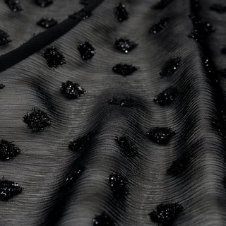 close-up of black crinkle chiffon with woven in sparkly black dots, detailing the transparency and crinkly weave structure
