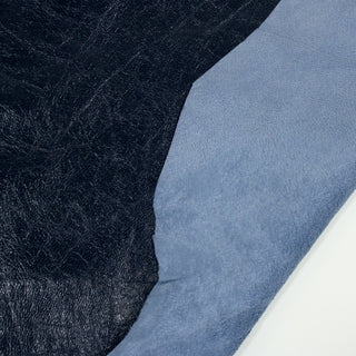 front and back of a blue lambskin leatherhide. Front is very dark blue with a glossy sheen to its surface, as well as a slight crinkle texture throughout. Back is light blue and lightly sueded.