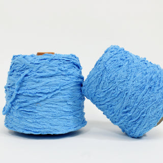 two large cones of blue textured yarn