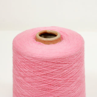close-up of a cone of ultra-fine, luxurious bubblegum pink colored yarn