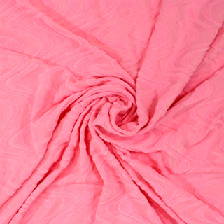 swirl of bubble gum pink colored knit fabric with a velour ripple pattern throughout