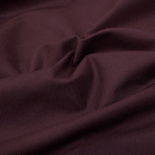 close-up of burgundy gabardine fabric, demonstrating the crisp hand and detailing the twill weave