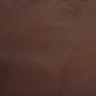 face of a burnt sienna brown colored calfskin leather hide