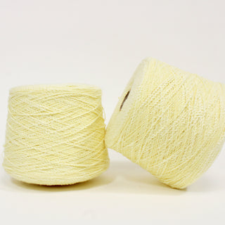 two large cones of butter-yellow colored curly slub yarn