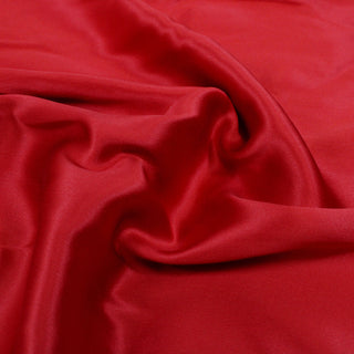 close-up of cherry red silk double-faced charmeuse fabric detailing its weave and shiny face