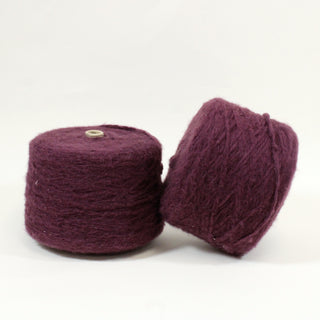 two large cones of deep chianti colored bulky yarn