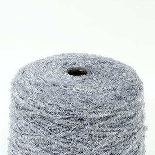close-up of a large cone of coin grey eyelash yarn with a fuzzy pile 