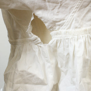 hole in side seam of cropped white blouse