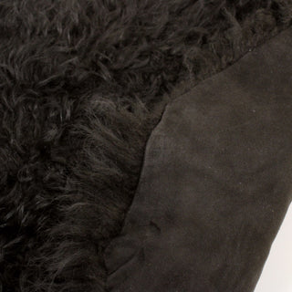 front and backsides of a dark clove colored long-shearling hide of a curly texture with a sueded back