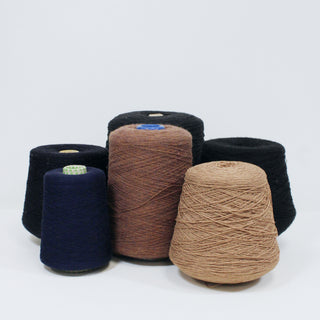 six varying cones of yarn in dark neutral colors
