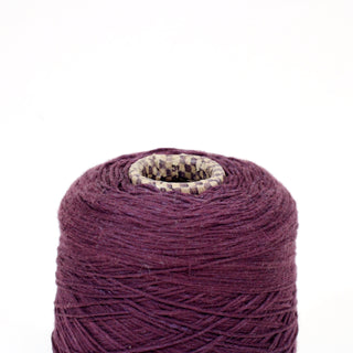 close-up of an eggplant colored yarn cone of a fine gauge