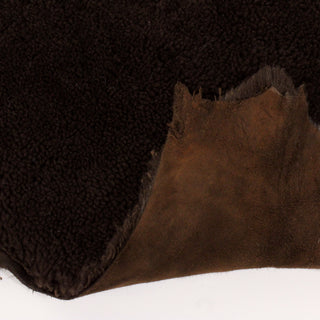 front and back of espresso brown colored shearling hide. face is curly shearling and backside is a slightly-lighter color suede