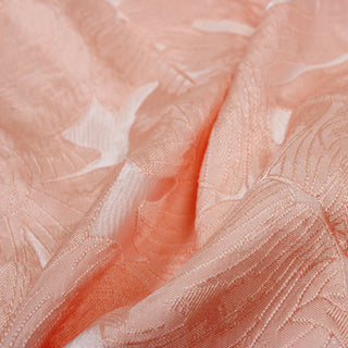 close-up of flamingo pink brocade fabric with leaf motifs on it, detailing the jacquard weave structure and slight surface shine