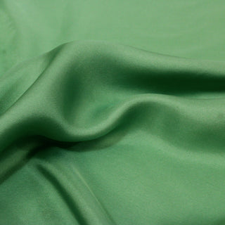 close-up of grasshopper green colored silk mikado fabric, detailing its twill weave