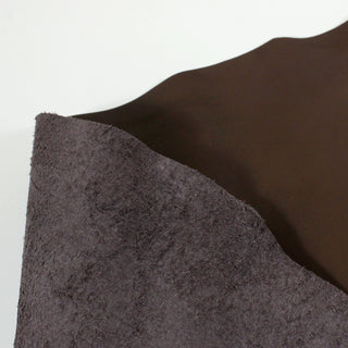 both sides of a deep hickory brown colored piece of cowhide: face a smooth leather, back a slightly-soft lighter brown suede