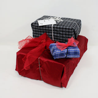 a pile of presents wrapped in holiday themed repurposed fabric scraps