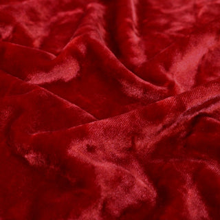 close-up image of crushed holly red velvet fabric, showcasing hand a pile quality of the fabric