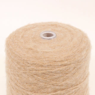 close-up of a large cone of latte beige colored fine-gauge fuzzy yarn