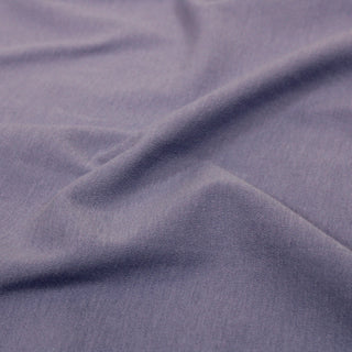 close-up of a knit jersey interlock fabric in a lavender color, detailing its knit structure and slightly rough hand