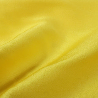 close-up of lemon yellow crepe back satin fabric detailing the weave and shiny face
