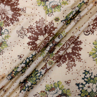 three diagonal lines draped of a very lightweight tan colored broadcloth fabric that's block printed with botanical motifs