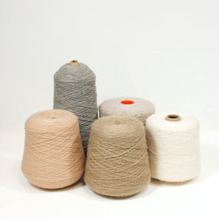 five varying cones of yarn in light neutral colors