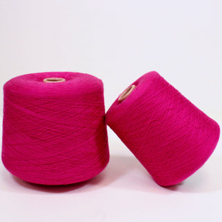 two large cones of magenta colored ultra-fine luxurious yarn