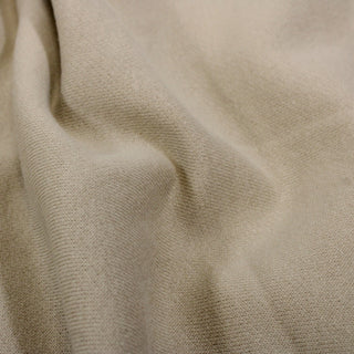 close-up of oatmeal colored french terry fabric, showing the knit structure of the face