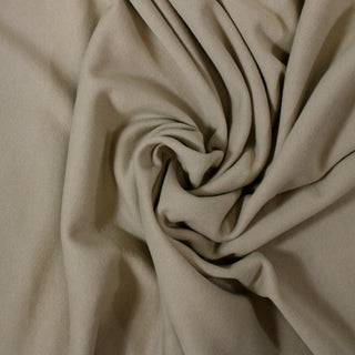 swirl of oatmeal colored french terry fabric, showing the thick drape