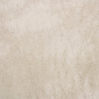face of an off-white colored shearling lamb hide, showing its slightly curly mid-length pile