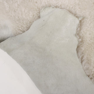 front and back of a lambskin hide, off-white shearling on one side and cloud grey suede on the back