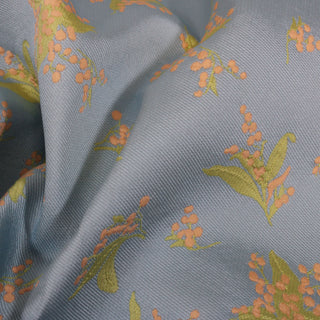 close-up of a light blue pastel floral jacquard twill fabric, detailing the weave structure and motif