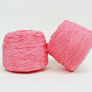 two large cones of pink textured yarn