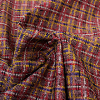 close-up of a textural woven-plaid fabric in purple, yellow, black, red, blue