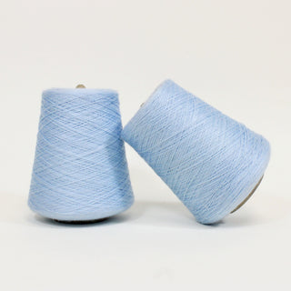 two cones of powder blue colored acrylic yarn