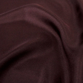 close-up of raisin colored silk mikado fabric, detailing the subtle shine and twill weave