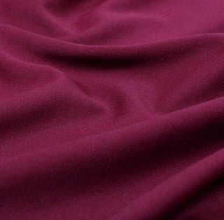 close-up of raspberry color tricot knit fabric, detailing the knit structure and face