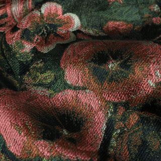 close-up of a jacquard-woven silk fabric of raspberry pink and dark green floral