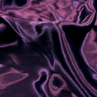 close-up of royal purple colored charmeuse fabric, detailing the shiny face, soft yet structured drape, and glossy surface